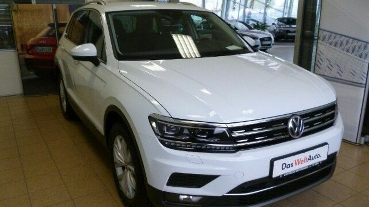 Frontansicht eines weißen VW Tiguan. Stehend in einem Showroom