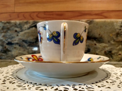 A VINTAGE COLORFUL CERAMIC TEA CUP & SAUCER SET WITH GOLD TRIM & WORN MARKINGS