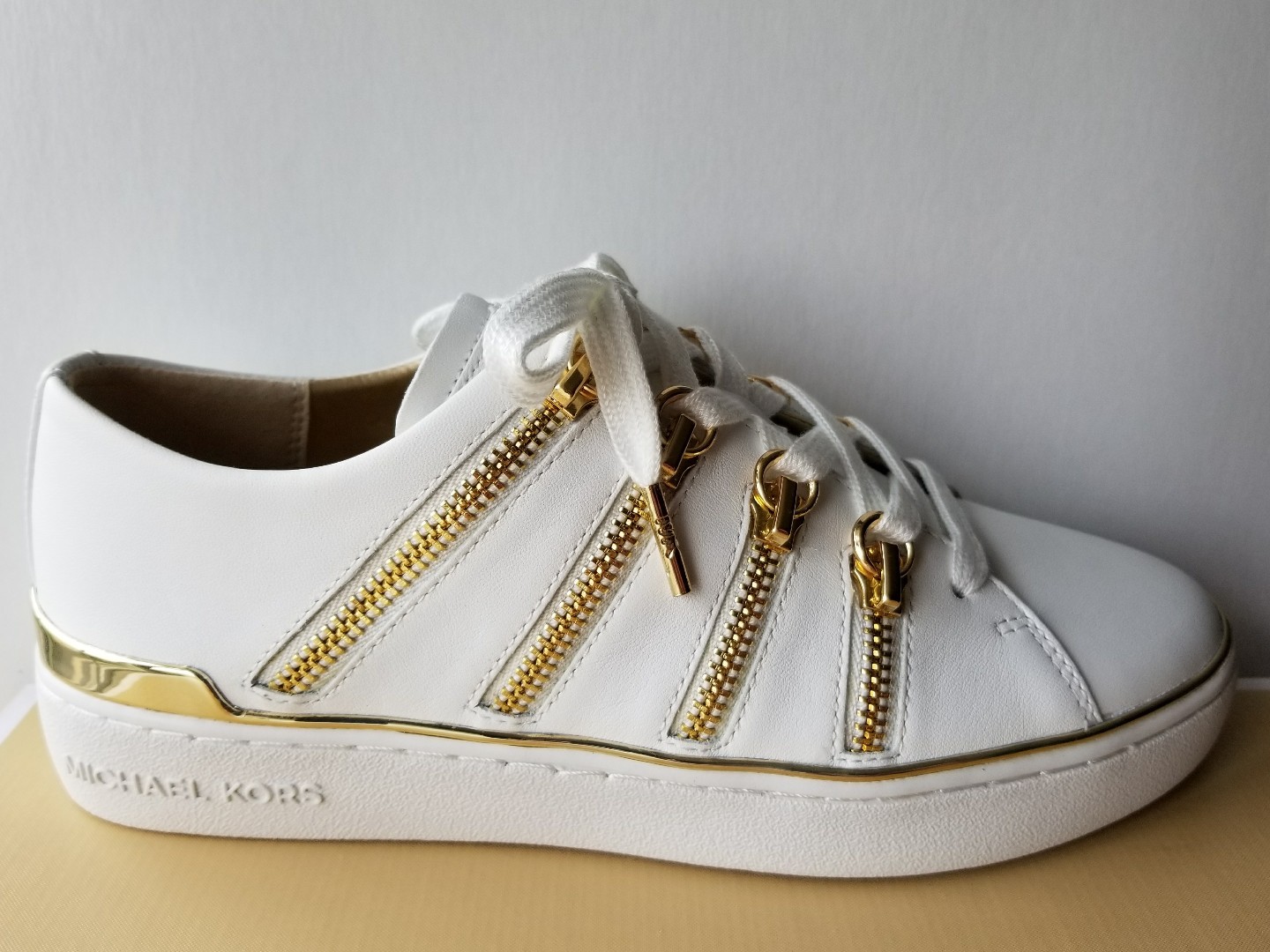 white sneakers with gold zipper