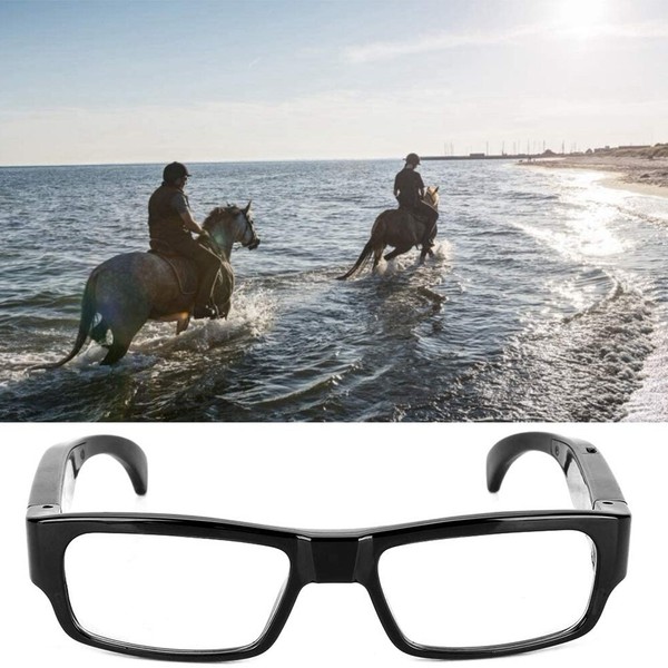 Two riders on horses at beach, black framed glasses.