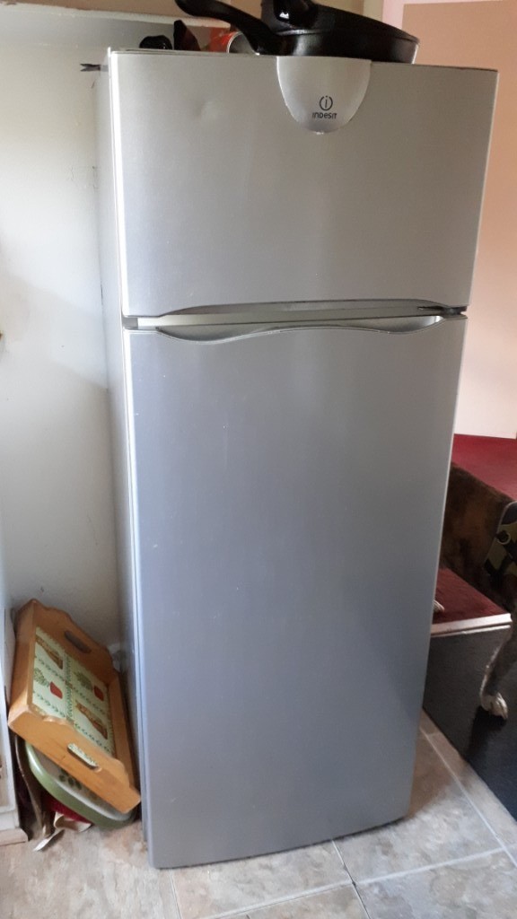 Silver larder fridge with small separate freezer compartment in