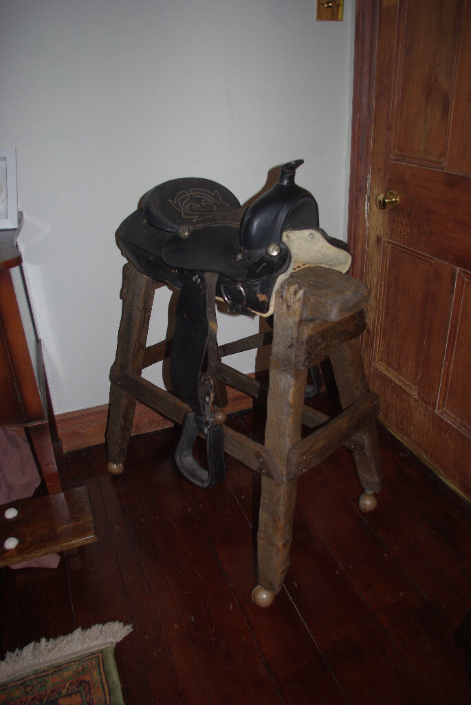 Bar stool featuring Western leather horse saddle as a seat in