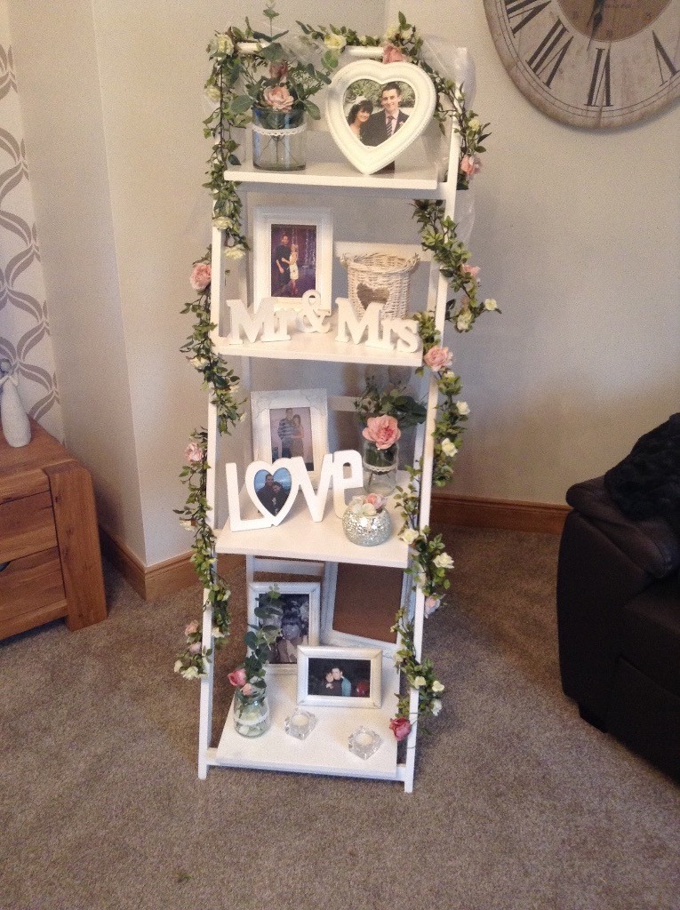 White wedding or engagment shelves with garlands photo frames and