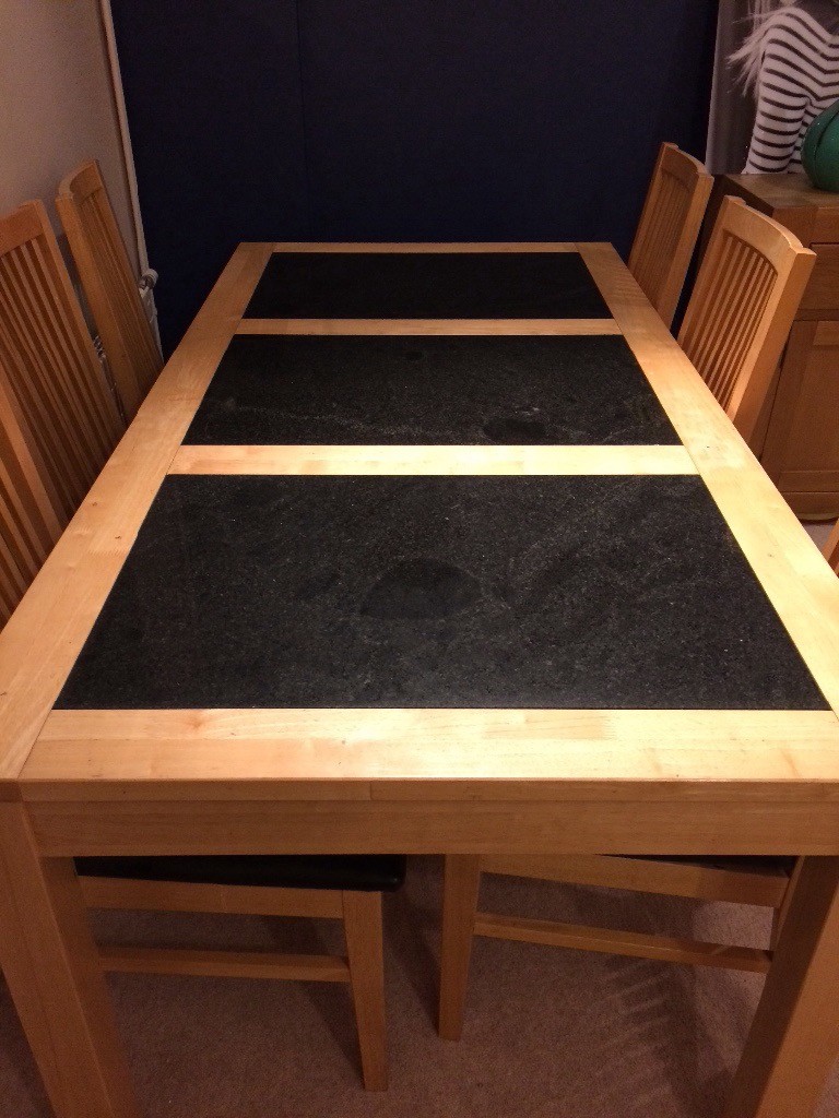 Blonde wooden dining table with black inlaid marble panels 