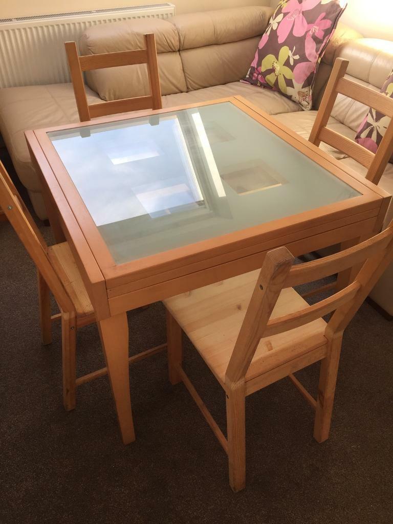 Glass topped extendable dining table and four wooden Ikea 