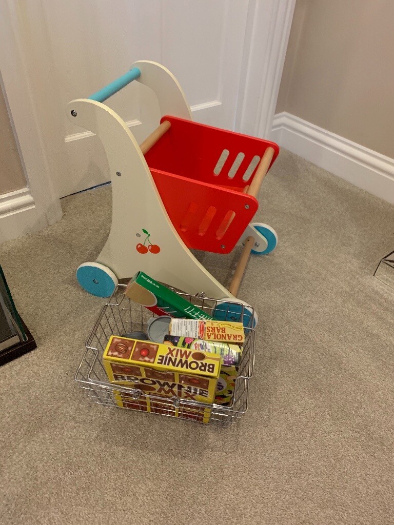 Wooden shopping trolley basket and pretend food in 