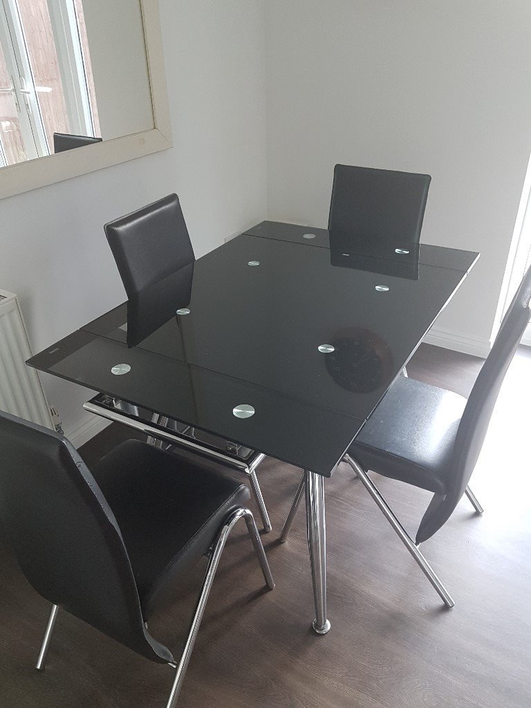 Extendable tempered glass dining table (black) with 4 black chairs in