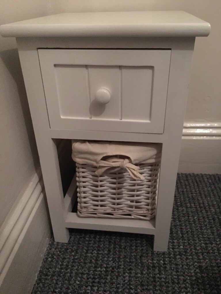 A pair of lovely white bedside tables with wicker baskets in
