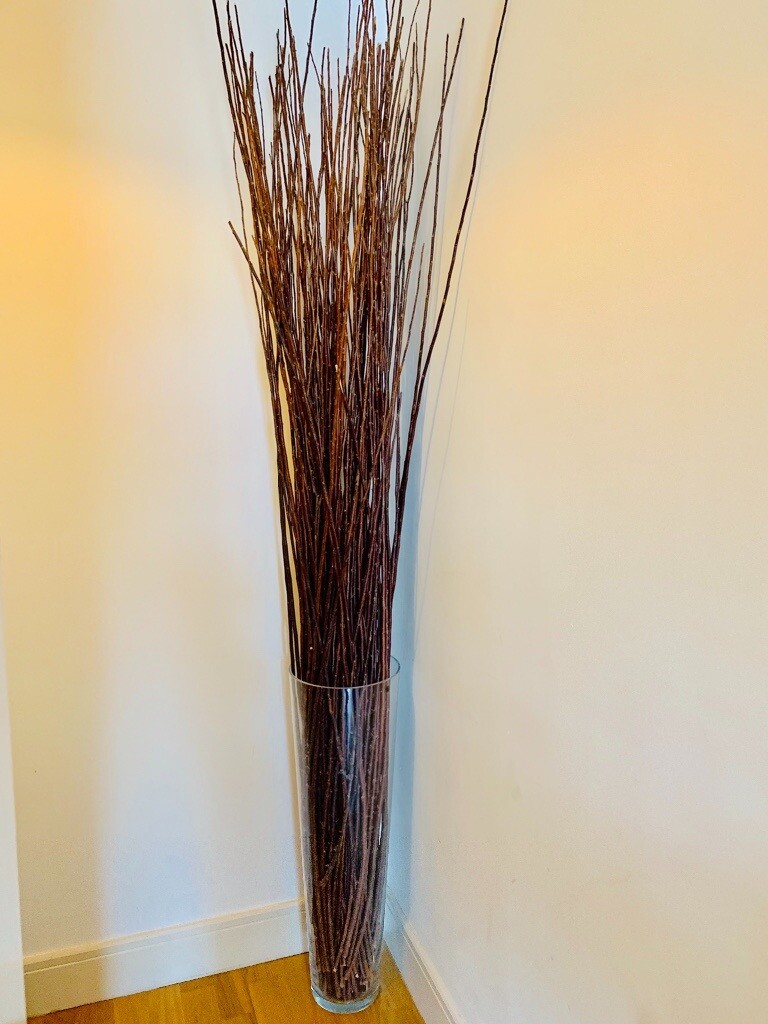 Large glass vase & decorative twigs. Almost full ceiling height