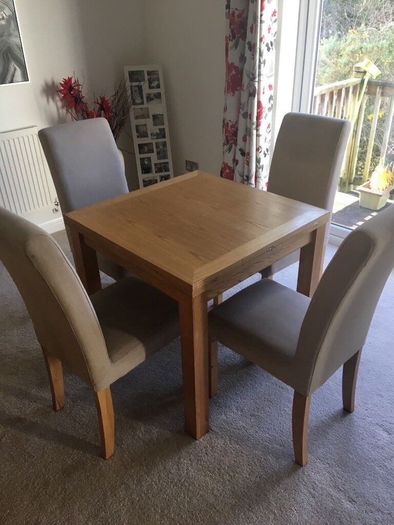 small oak extendable dining table and four chairs in