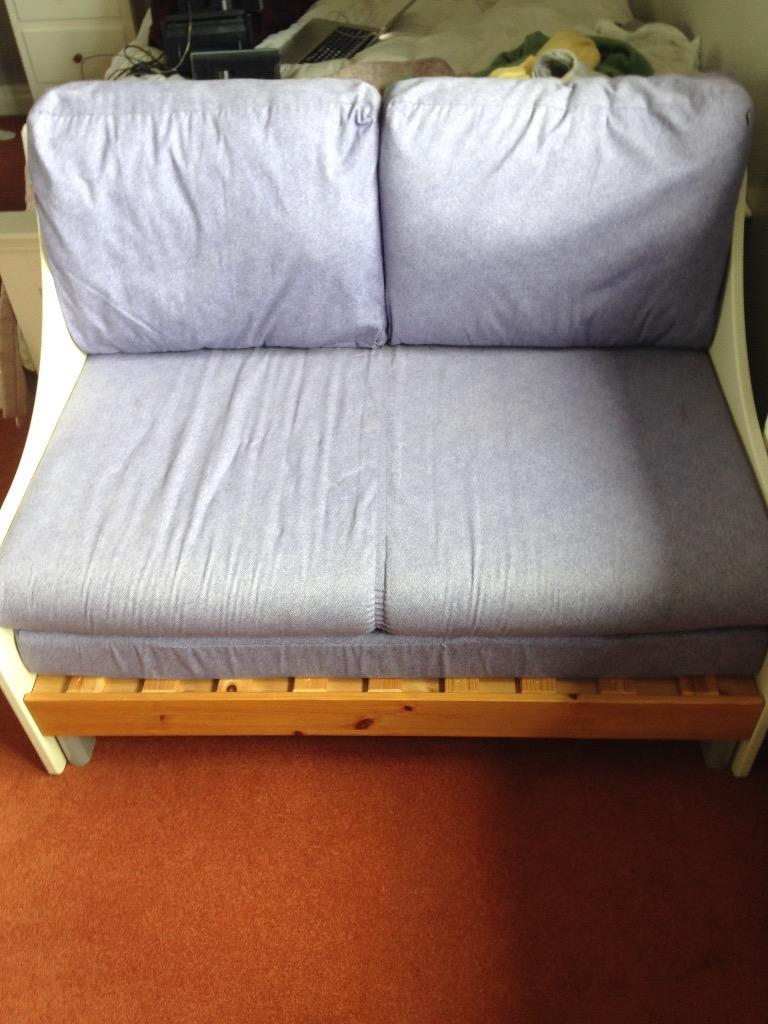 White and pine Stompa sofa bed with purple cushions in Sutton