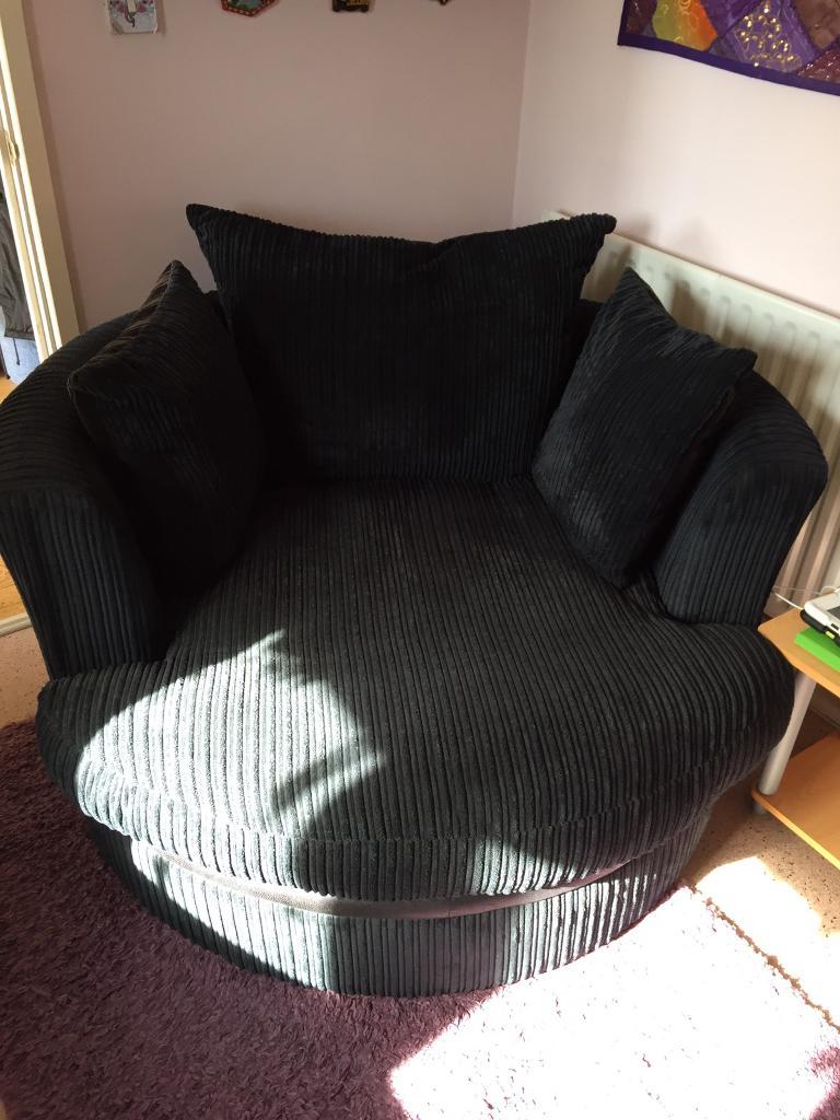 Black thick corduroy swivel chair with matching footstool in