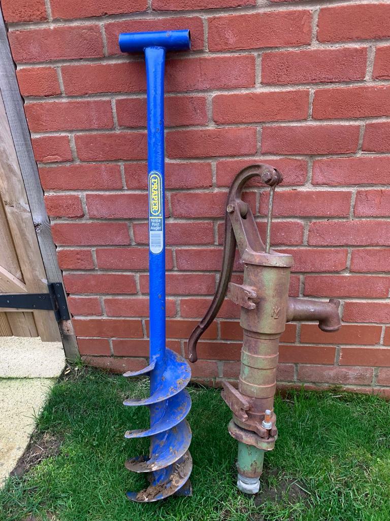 Antique hand water pump and fence post auger in Romsey, Hampshire