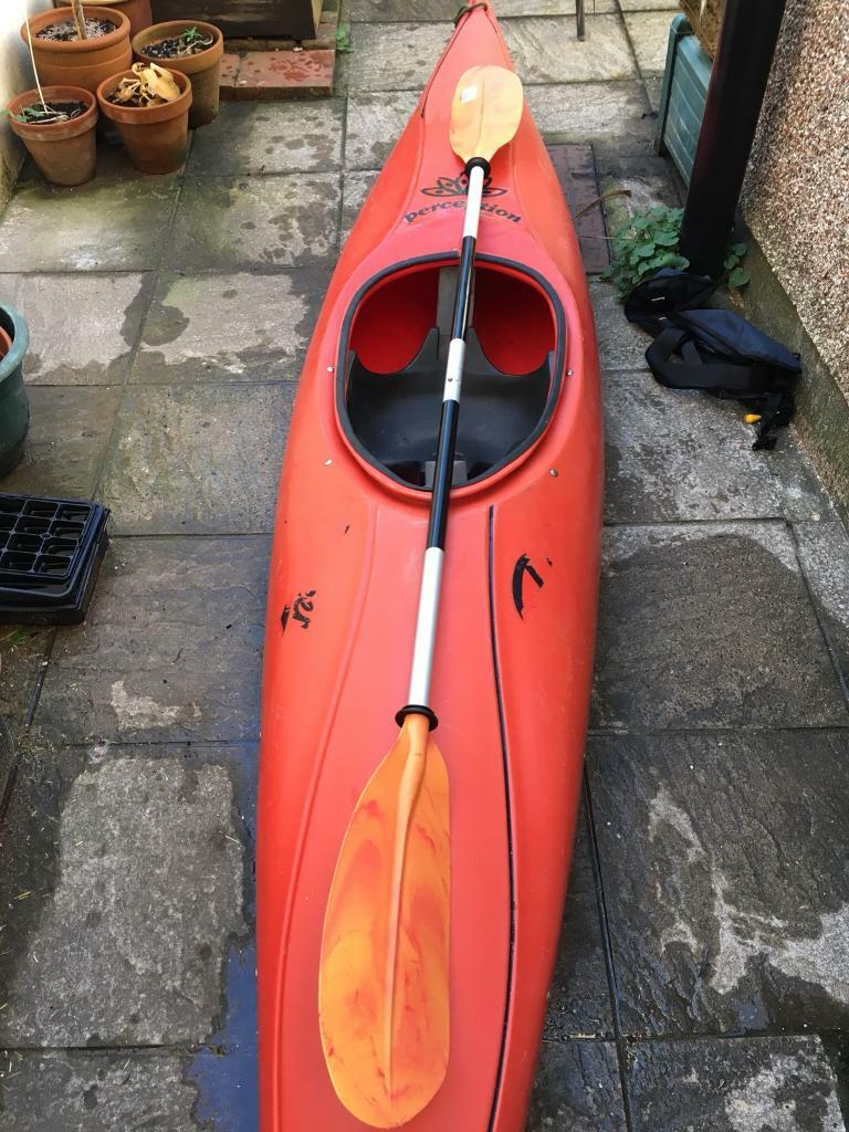 Red Perception Kayak with paddle and life jacket in St
