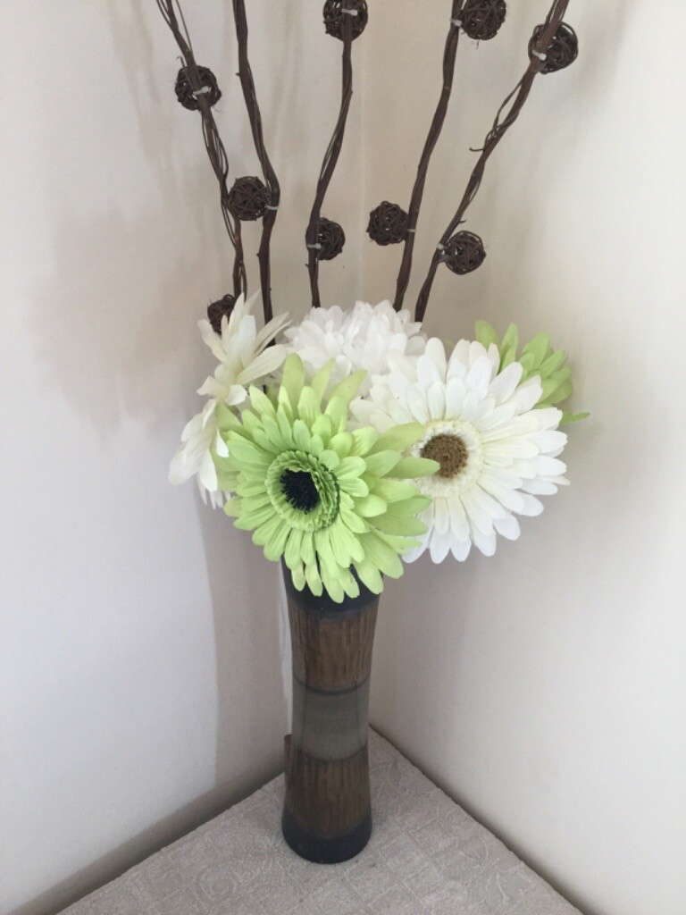 Tall vase with lights willow twigs and artificial flowers in
