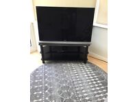 Sony 46in HD TV and black stand with sound bar