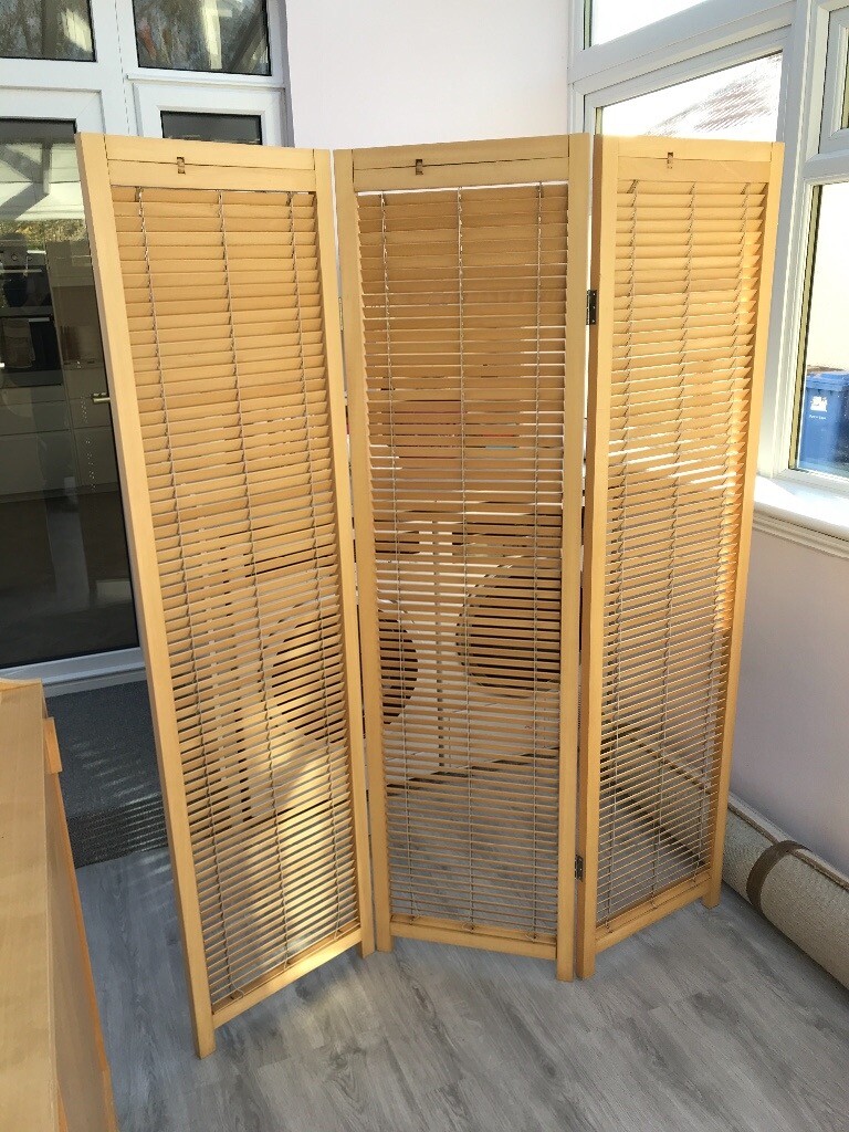 Wooden three panel room divider with blind sections. in