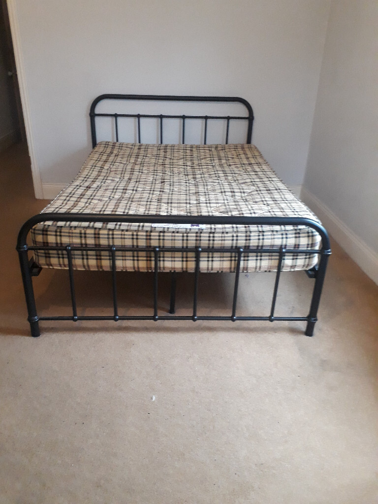 metal framed double bed with head and tail board and mattress in