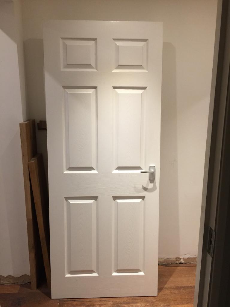 Howden’s 6 panel wood grain effect white fire door in Stratford