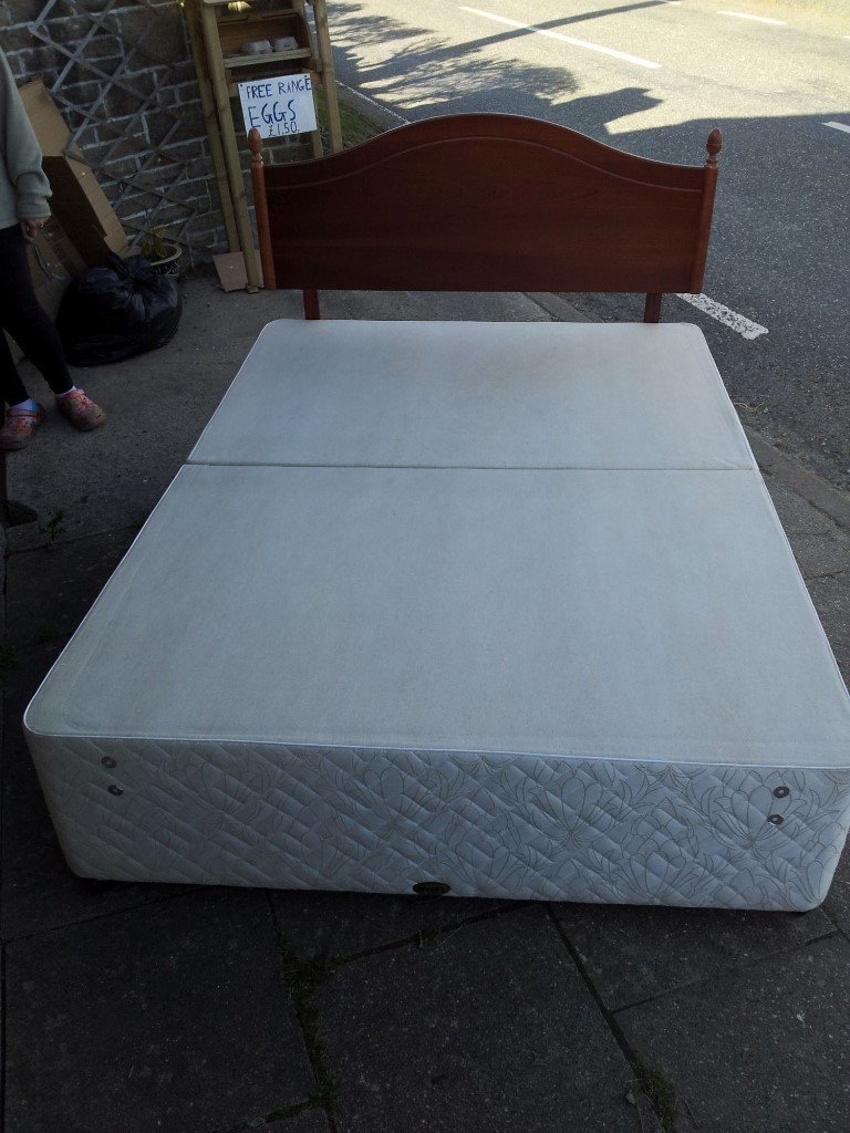 Double divan bed base with four drawers and wooden headboard in