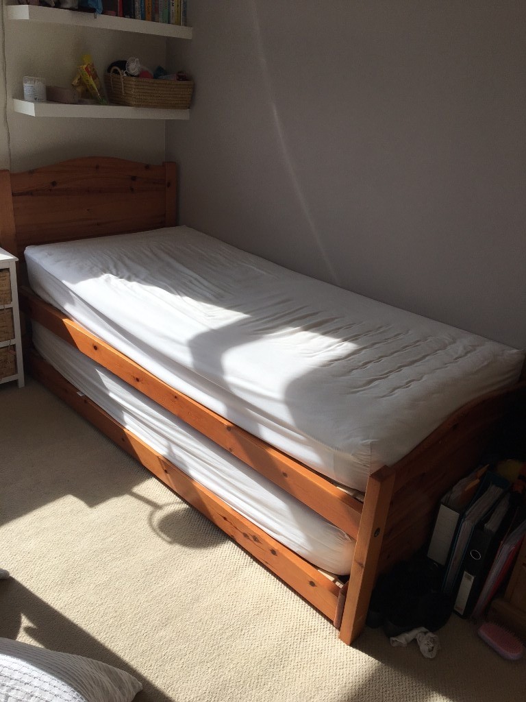 Pine single bed with single size trundle bed frame tucked under bed