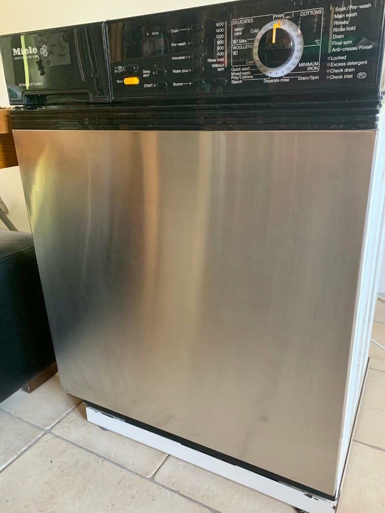 Miele washing machine fully integrated under kitchen worktop. in
