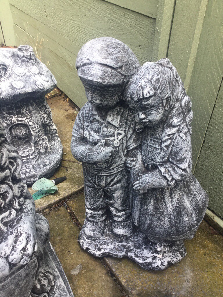 Stone garden ornament of a boy and girl holding hands in Hengoed