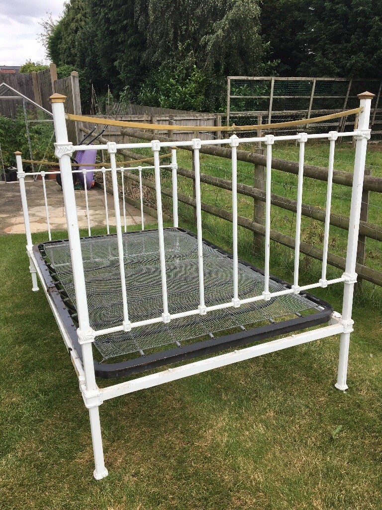 Antique bed frame with brass trim and spring base in Loughborough