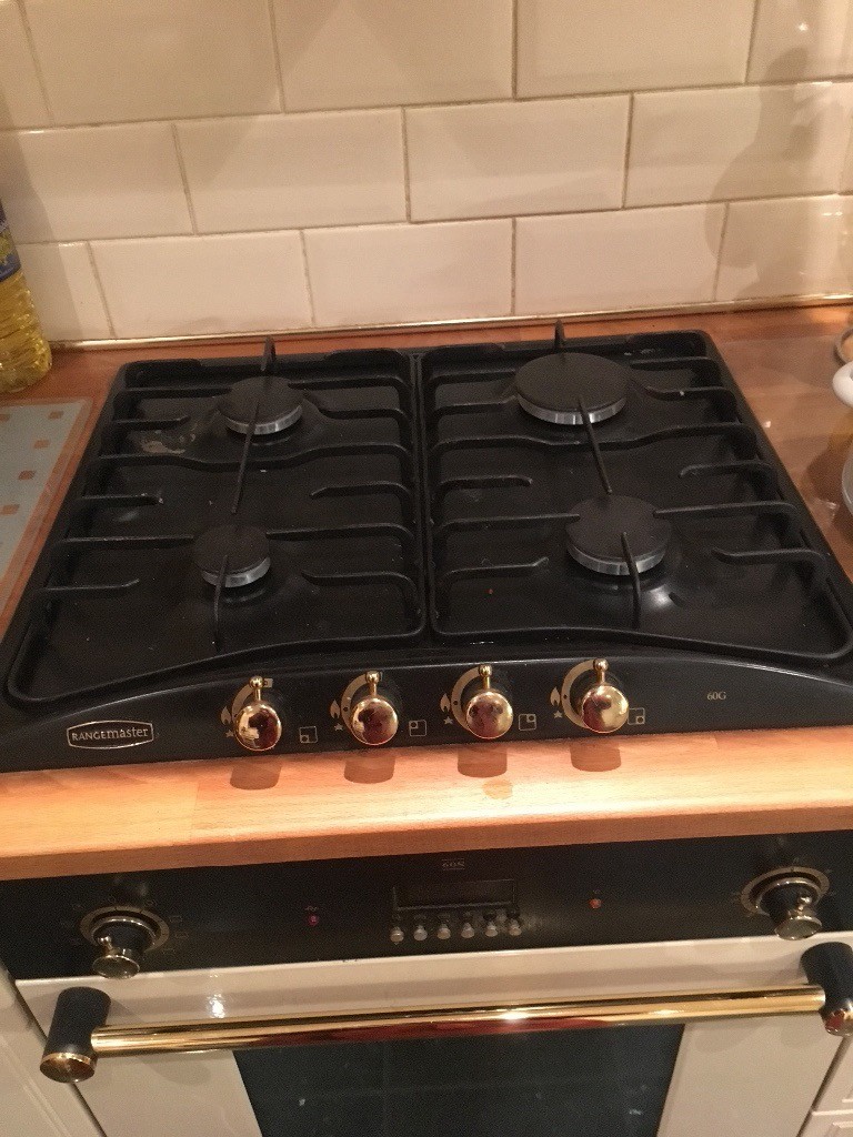Black and gold Rangemaster electric fan oven, gas hob, cooker hood and