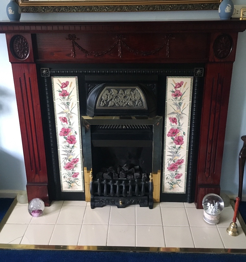 Victorian style tile fireplace surround with living flame gas fire in