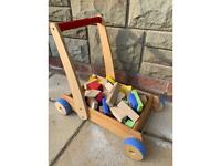 Large collection of over 260 coloured wooden blocks and wooden push along trolley ELC