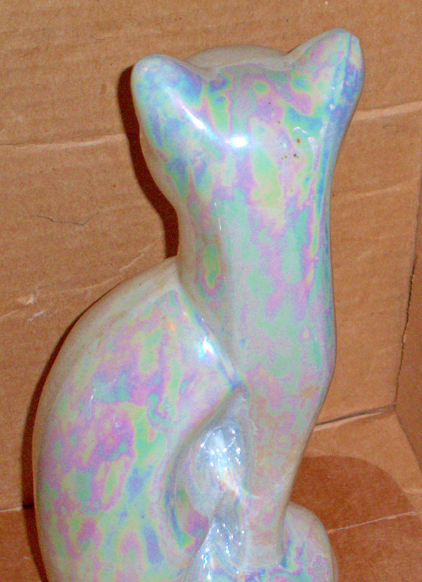 Eight and one half inch high pearlized cat made of a solid resin material.