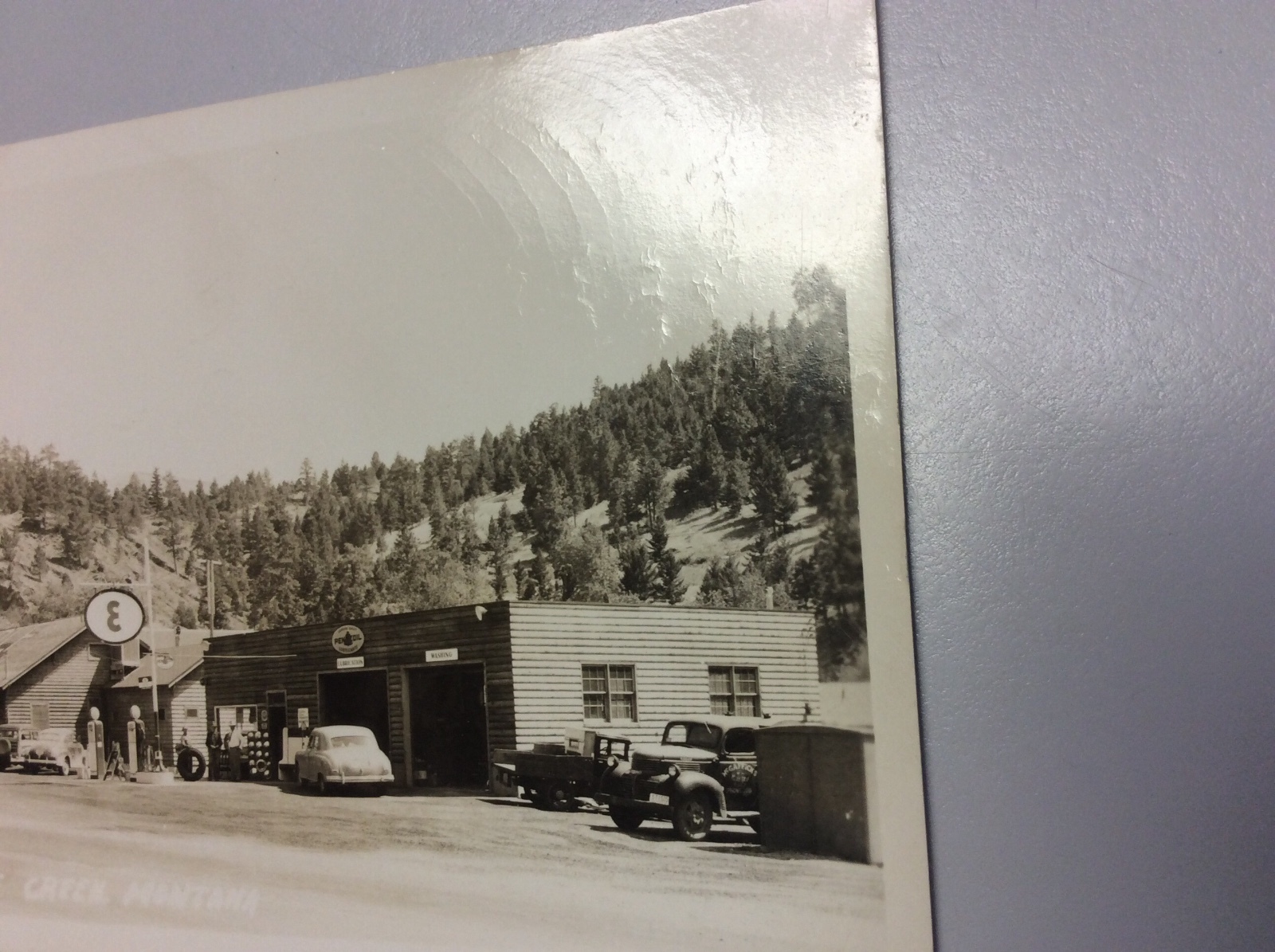 Real Photo Postcard of Frenchy's in Wolf Creek, Montana. Esso Gas and Pennzoil
