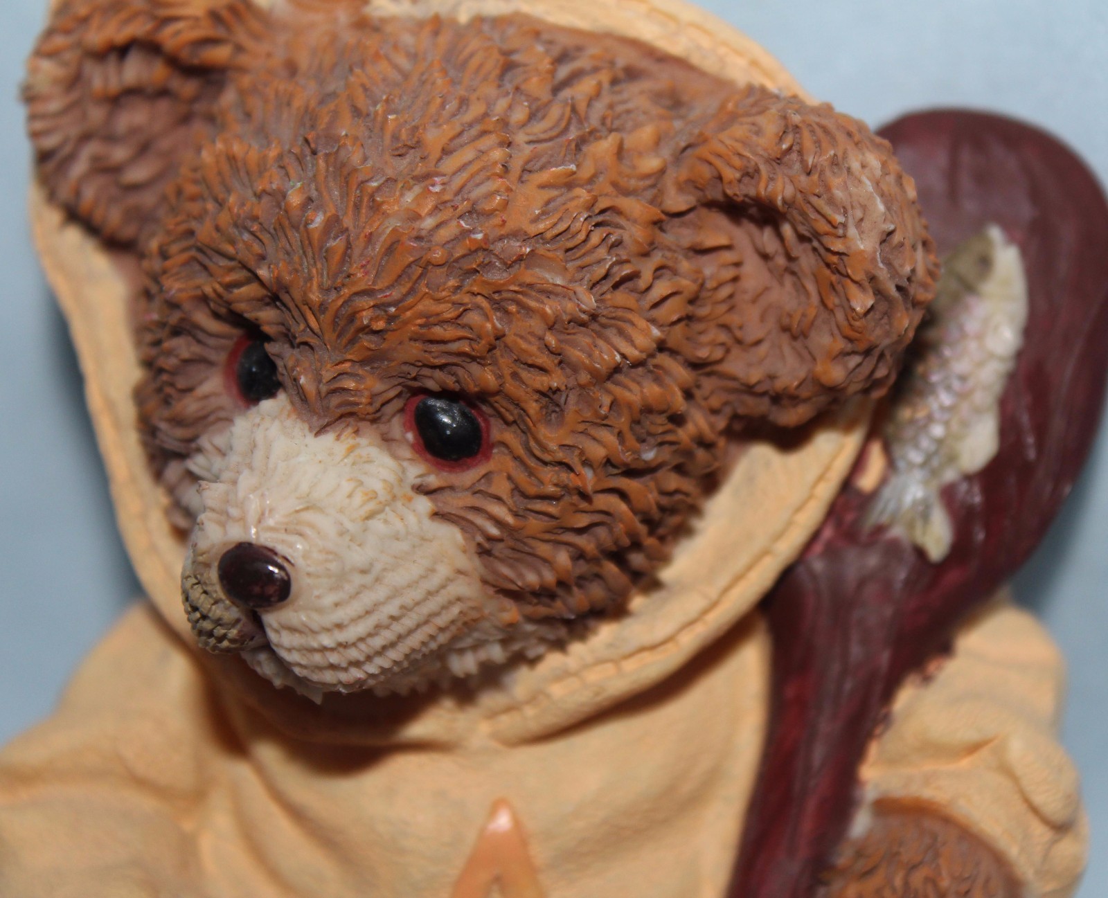 Bear figurine with fish and paddle. Hoodie w/ letter A