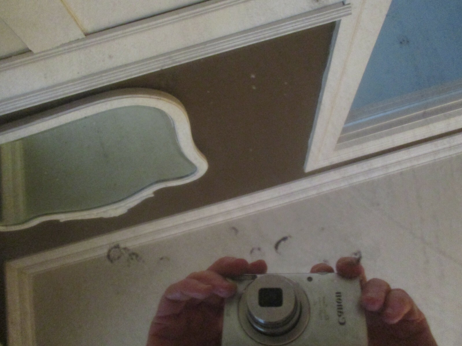 Antique beveled oval mirror. Creamy white.