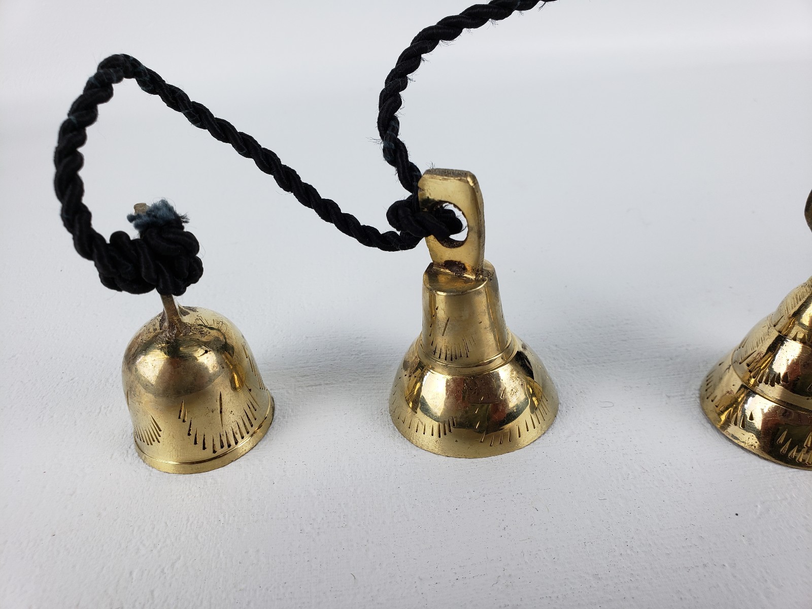 4 Brassy Bells Strung on a Black Rope India Different Shapes Different Sizes