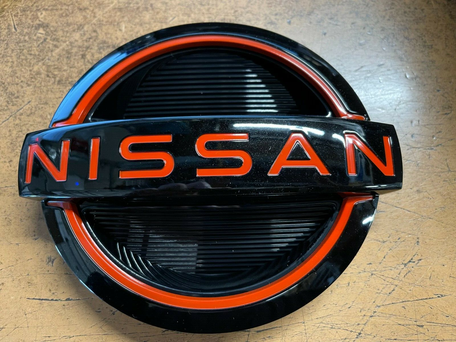 NEW OEM 2022-2024 NISSAN FRONTIER FRONT GRILLE EMBLEM - RED ACCENT 