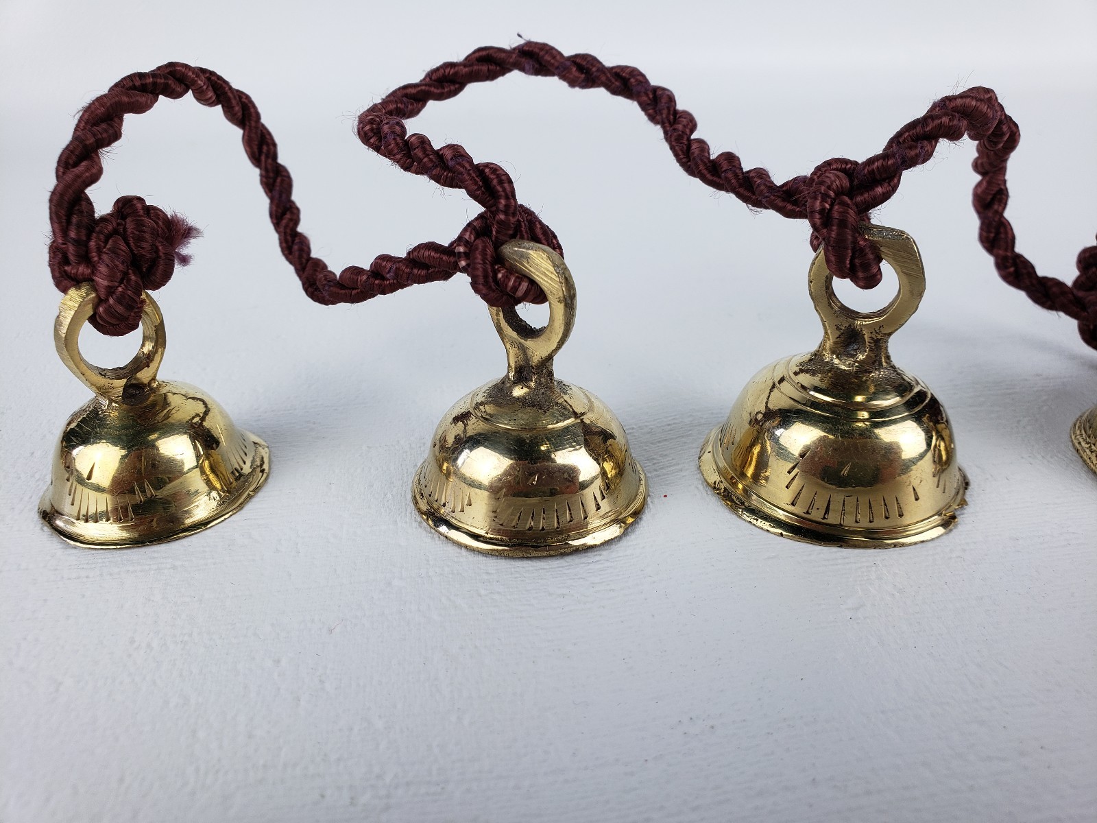 5 Brass Bells Strung on a Brown Rope India Same Shape Different Sizes