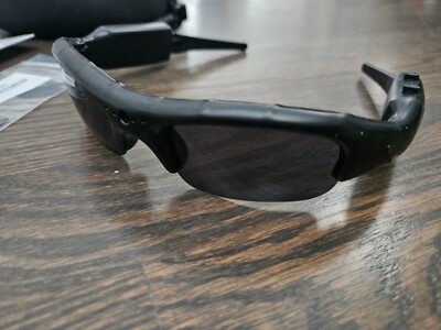 Black smart sunglasses on wooden surface.