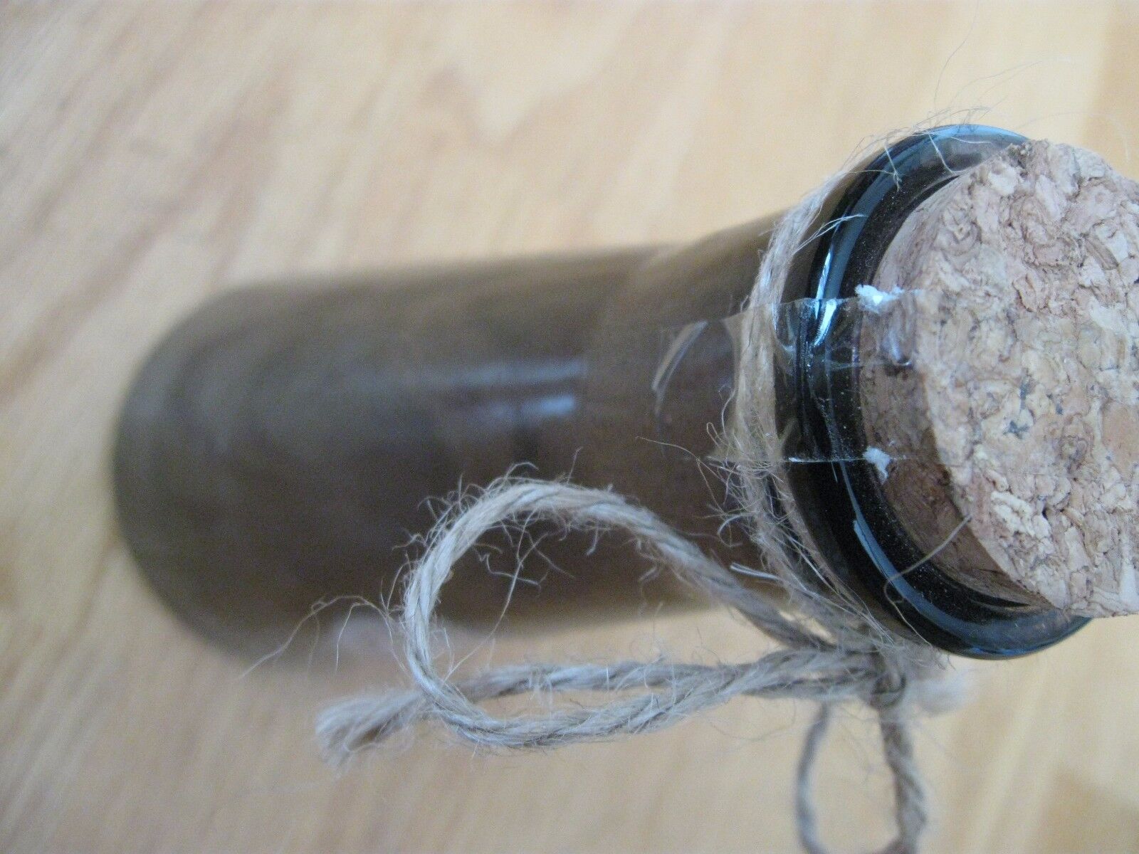 Finely Ground Raven Claws Label on a Corked and Sealed SmokeColored Empty Bottle