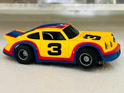 Tyco Porsche Carrera slot car. Yel/Blu/Red #3. Runs. Non lighted chassis.