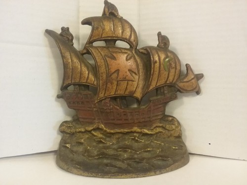 A CAST METAL SHIP ON THE WATER DOORSTOP