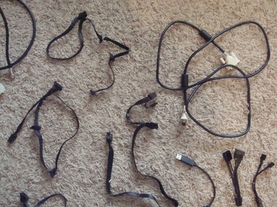 Lot of computer cables, cords, screws, and small parts