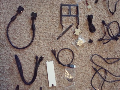 Lot of computer cables, cords, screws, and small parts