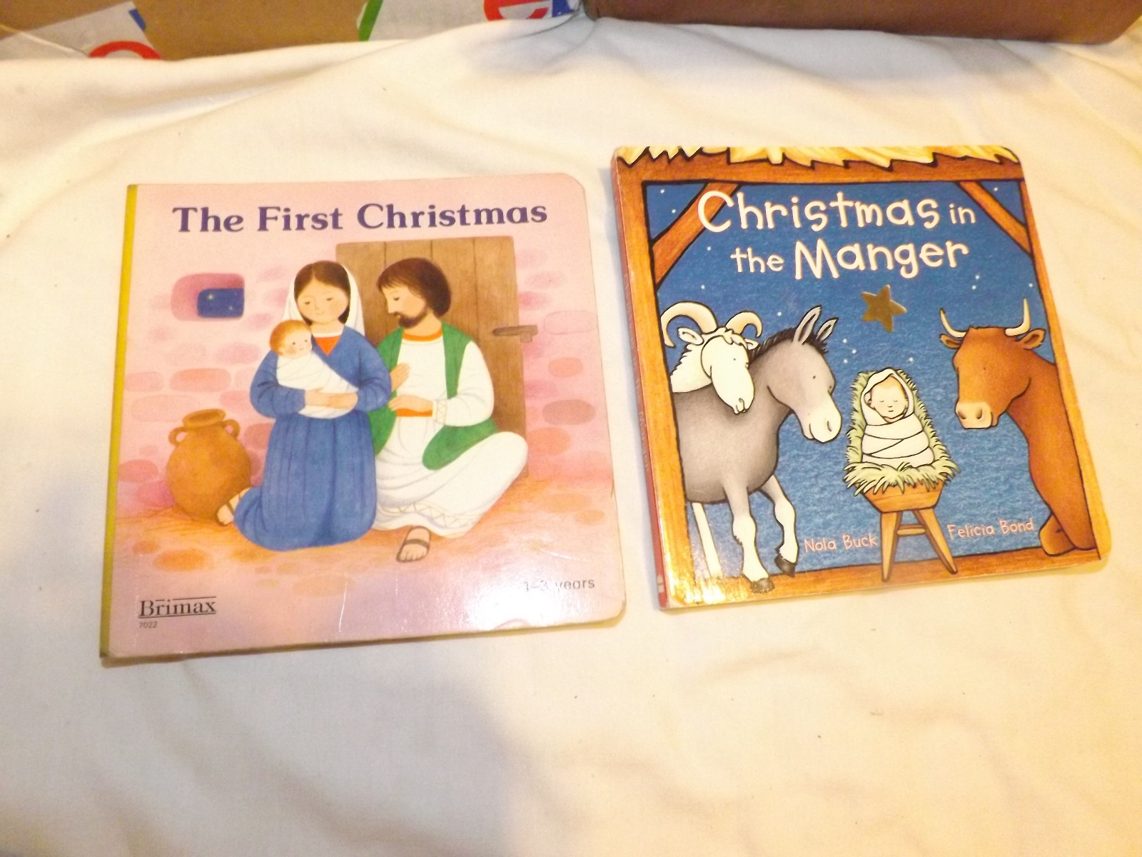 Nativity pair: The First Christmas + Christmas in the Manger; two cardboard kids