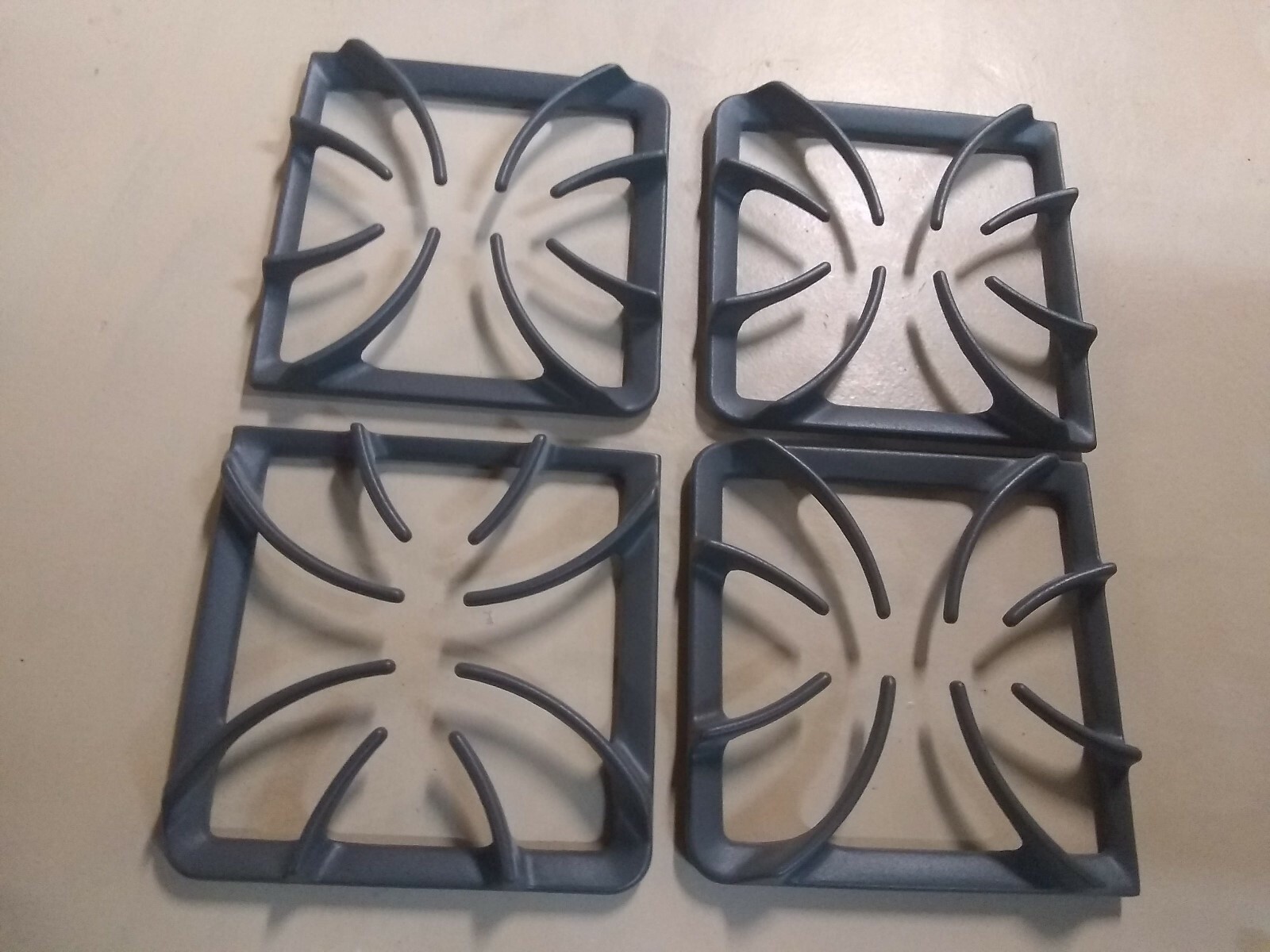 SET OF 4 BURNER GRATES BRAND NEW 9 1/4 INCHES X 9 INCHES (MAKER UNKNOWN)