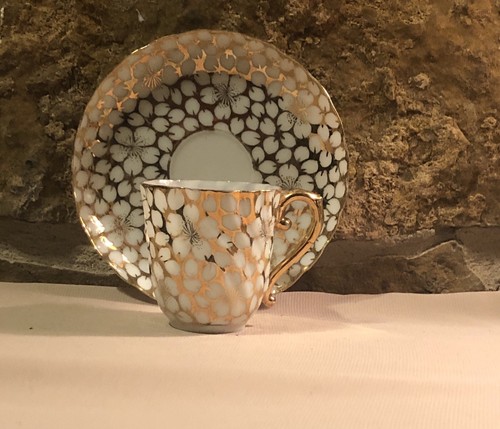 Tea Cup & Saucer gold with white flowers.