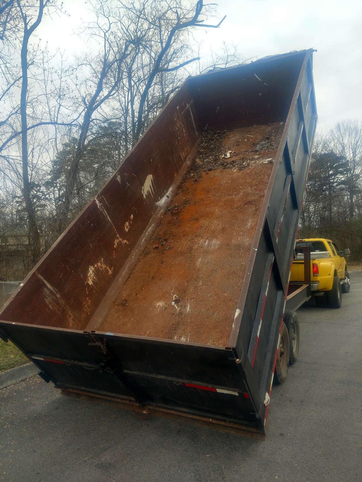 slightly used black metal gooseneck dump trailer