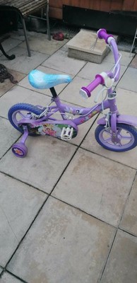 Girls Purple Petal Bike with stabilisers.