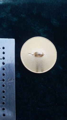 Pre owned metal mythology face gold tone with enamel clothes button.